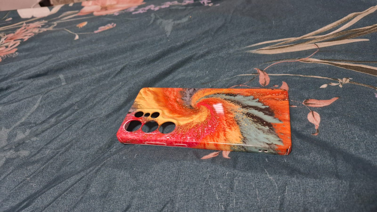 Firestorm resin art phone case flat lay on dark fabric